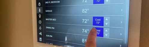 Paradise NV homeowner checking thermostat at night while AC blows warm air through vent