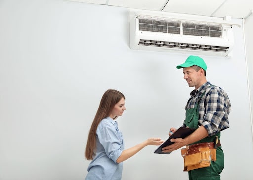 Las Vegas homeowner reviewing AC repair vs replacement options with a technician