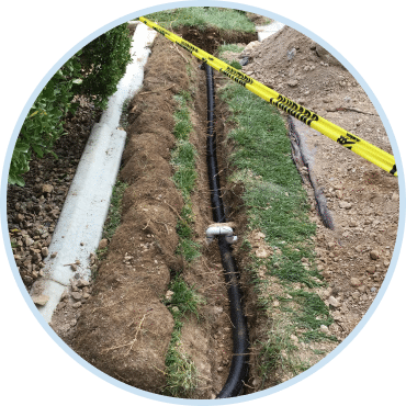 Sewer and drain service company installing new pipe in residential yard